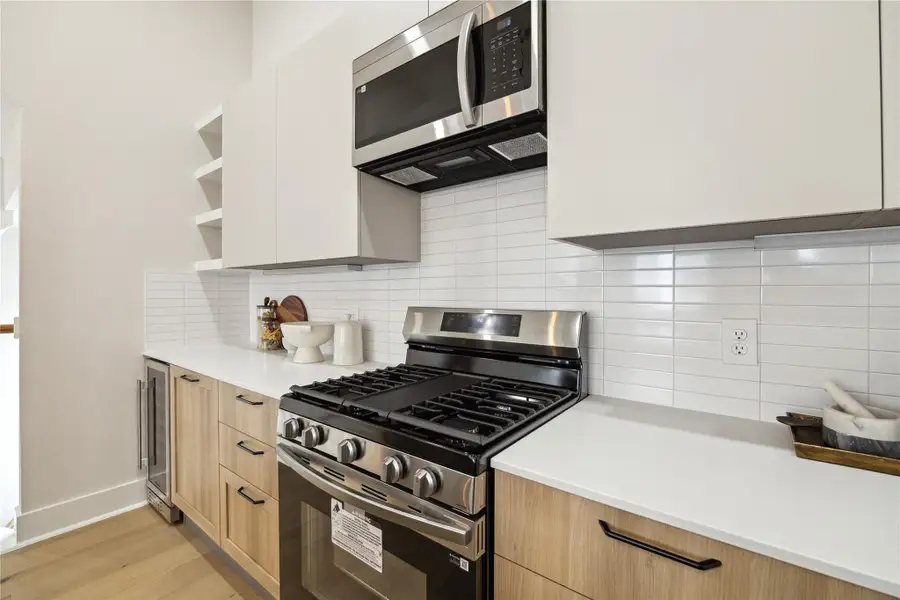 Modern kitchen featuring sleek cabinetry, stainless steel appliances, and a stylish tile backsplash, perfect for culinary enthusiasts.