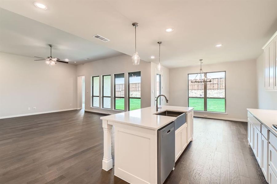 Kitchen with a center island with sink, white cabinets, sink, stainless steel dishwasher, and dark hardwood / wood-style floors