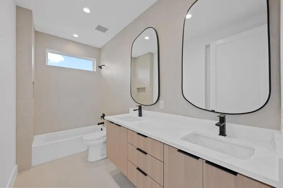 Full bathroom with shower / bathtub combination, double vanity, and recessed lighting