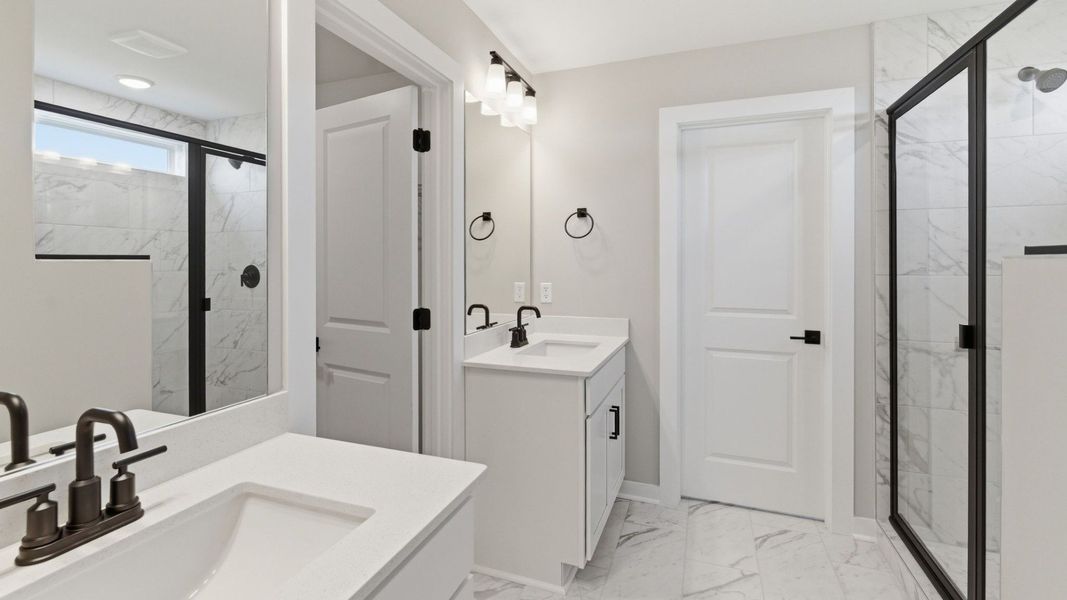 Bathroom with dual vanity and access to closet
