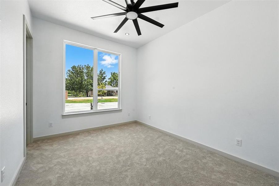 Empty room featuring carpet floors and ceiling fan Empty room featuring carpet floors and ceiling fan