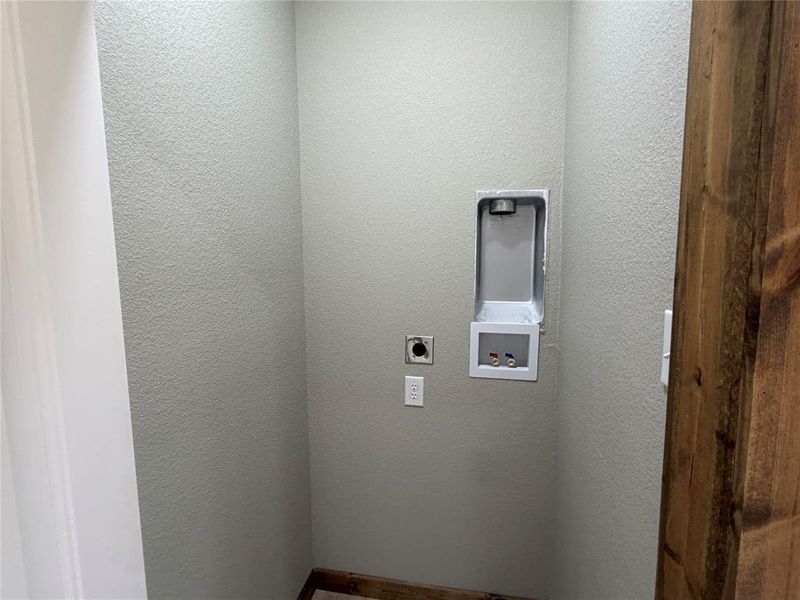 Dedicated laundry area featuring a recessed hookup box and stacked Washer & Dryer