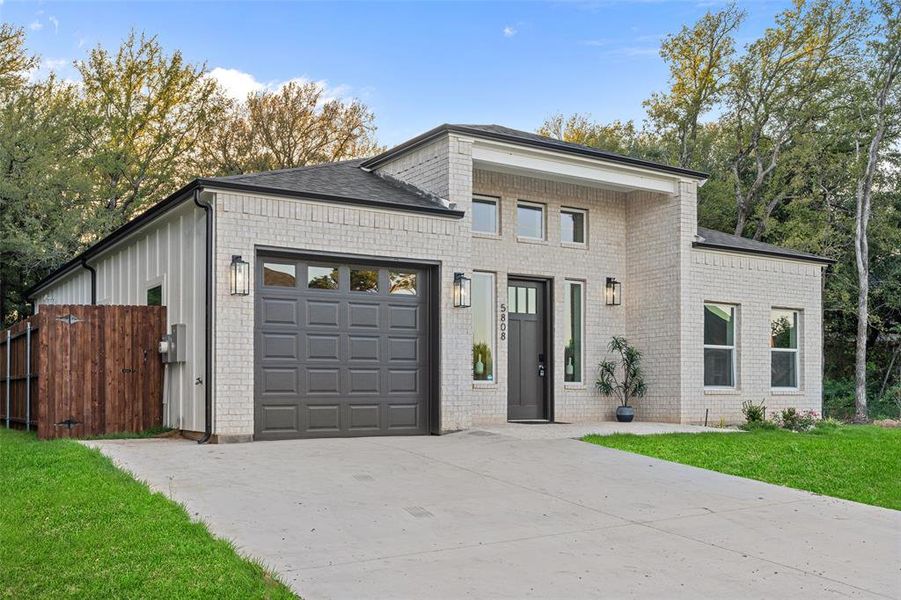 View of front of house featuring a front yard and a garage