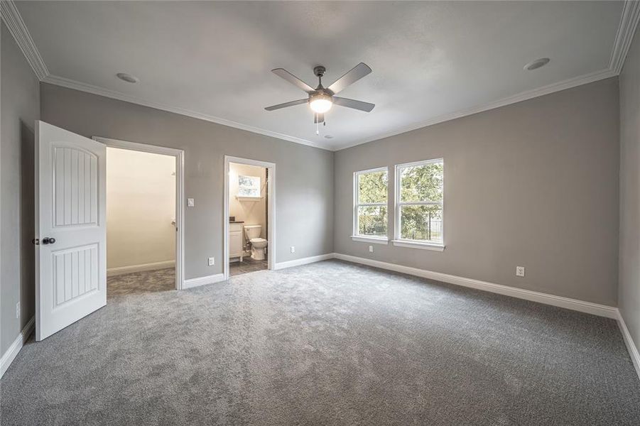 Unfurnished bedroom featuring connected bathroom, carpet, crown molding, and ceiling fan