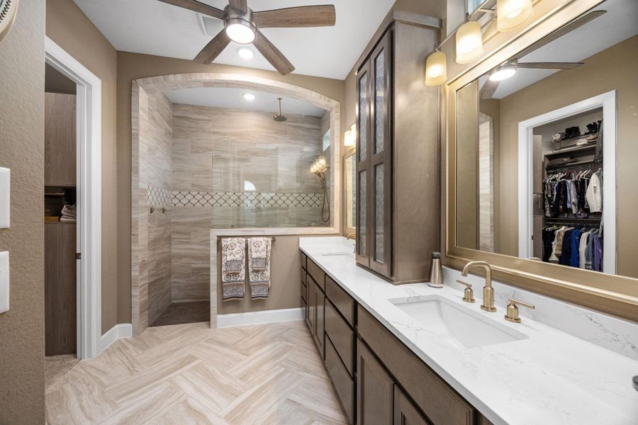 Herringbone tile, floor to ceiling with custom Marble Inset. Stunning arch amplifies the elegance of his owners retreat