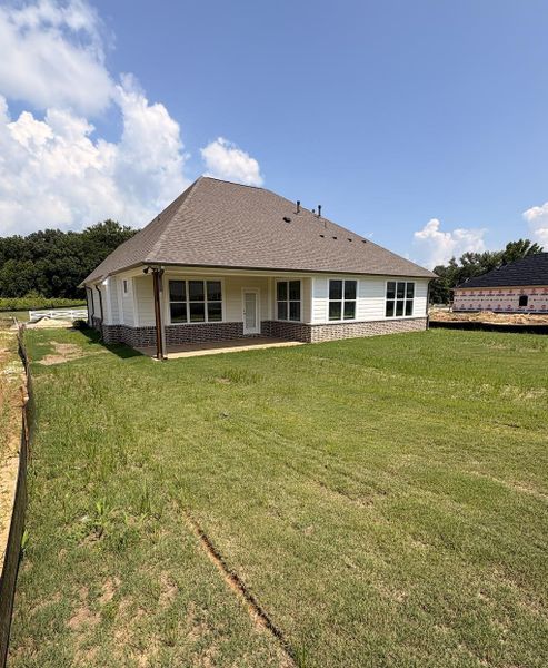Rear exterior with white siding and a brick-finish base Rear exterior with white siding and a brick-finish base