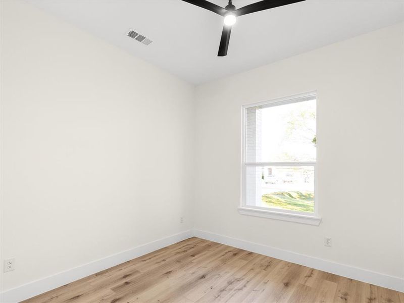 Empty room with light wood finished floors and a ceiling fan