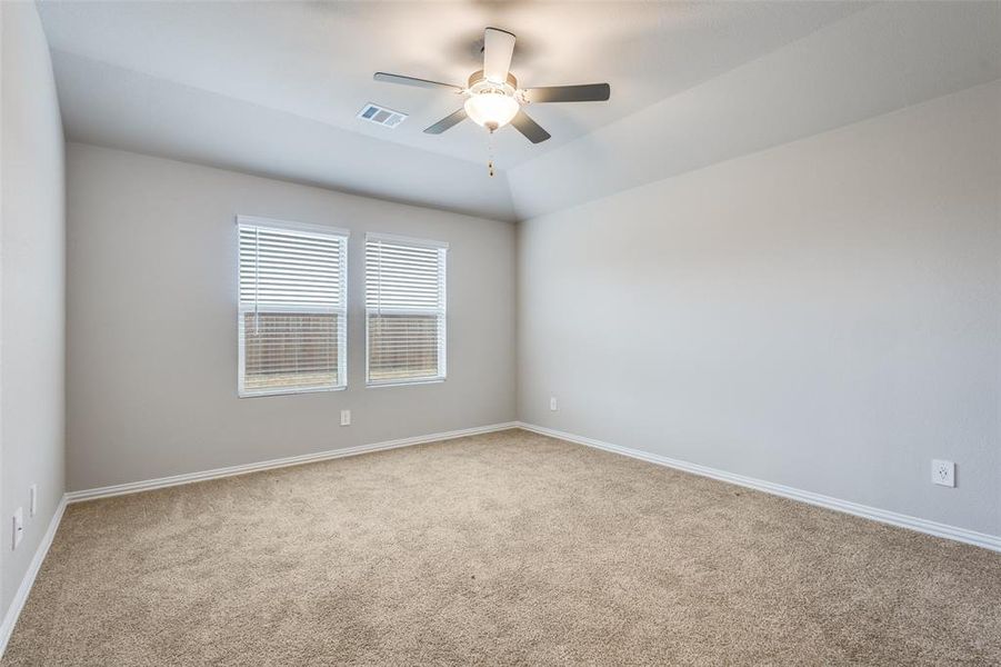 Empty room with light carpet, lofted ceiling, and ceiling fan