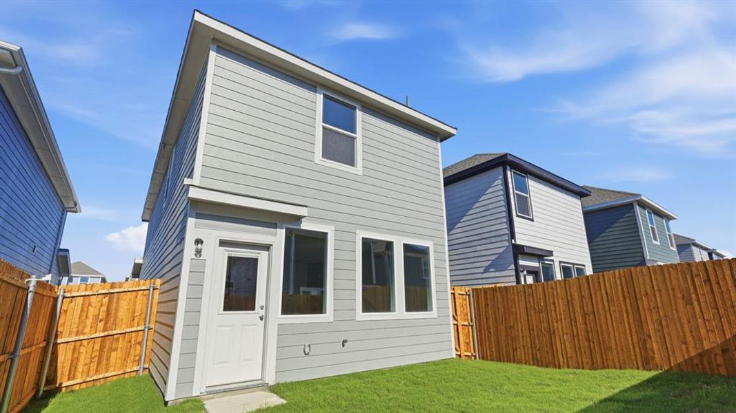 Rear view of house featuring a fenced backyard