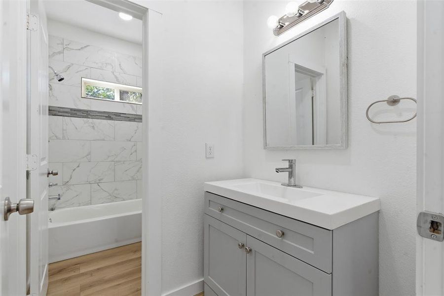 Full bath with vanity, tub / shower combination, and light wood-type flooring Full bath with vanity, tub / shower combination, and light wood-type flooring