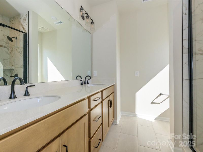 En suite primary bath complete with dual vanity and more than enough storage.