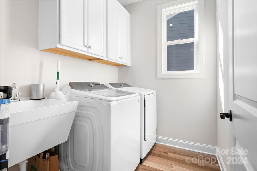 Generous-sized Laundry Room has low maintenance LVP flooring, added overhead cabinets and an added Laundry sink.