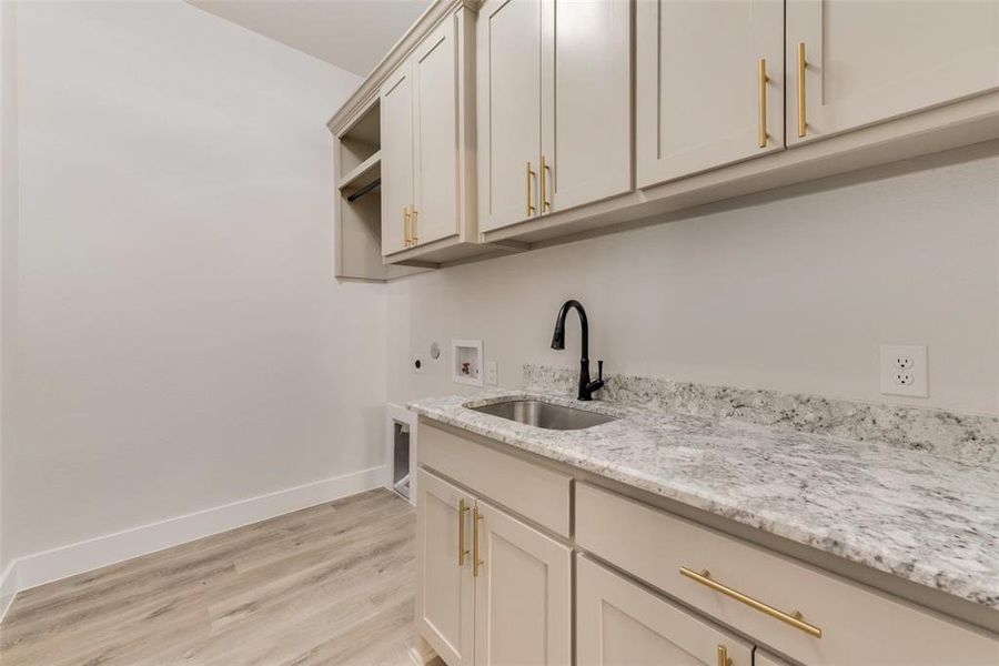 Laundry area with washer hookup, light wood-style floors, cabinet space, hookup for an electric dryer, and gas dryer hookup Laundry area with washer hookup, light wood-style floors, cabinet space, hookup for an electric dryer, and gas dryer hookup