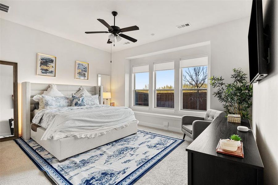 Carpeted bedroom featuring baseboards, ceiling fan, and visible vents