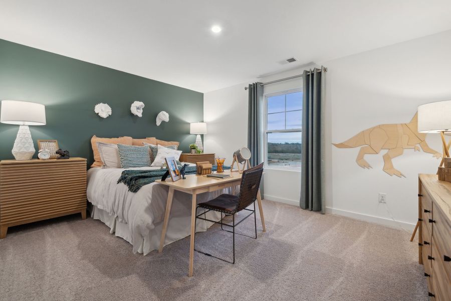 A bedroom with a bed desk and a chair.
