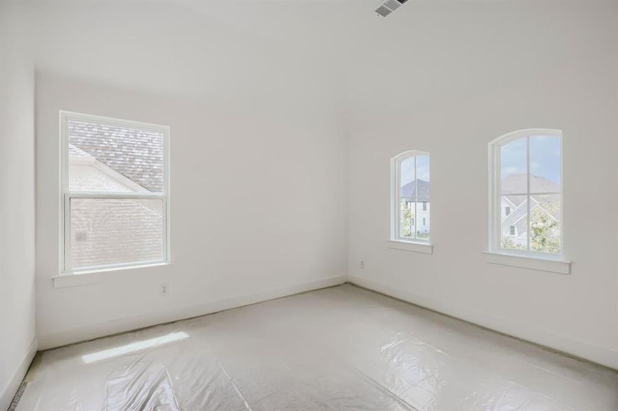 Spacious room featuring three windows, including two arched windows and one rectangular window Spacious room featuring three windows, including two arched windows and one rectangular window