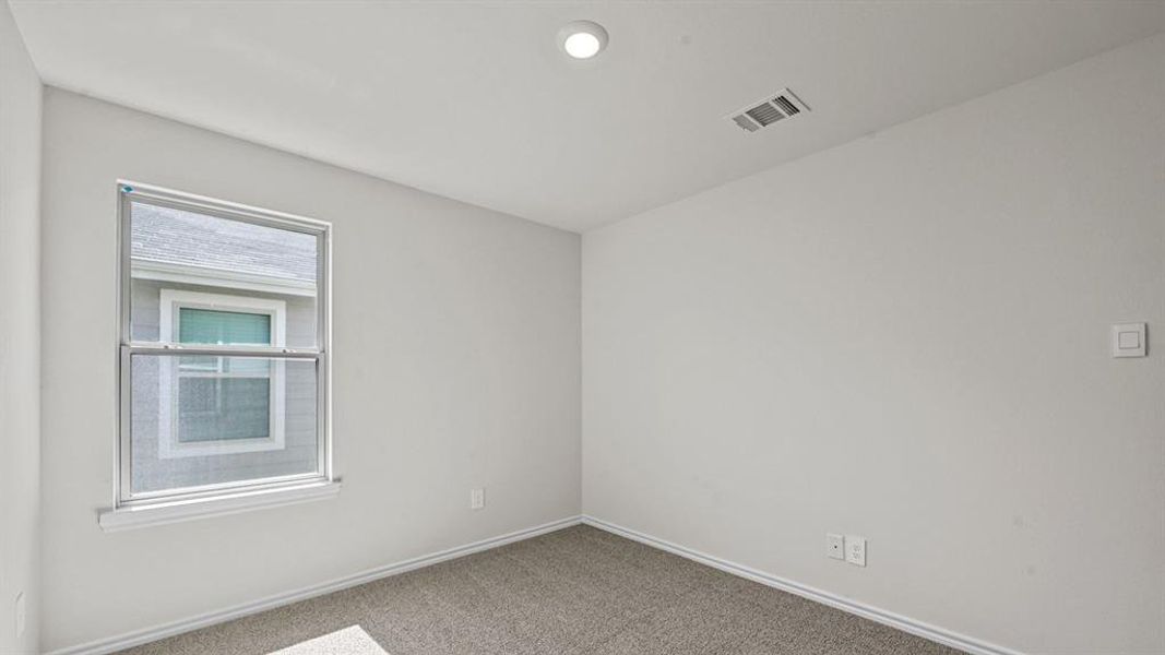 Neutral-toned carpeting complements the light wall paint and white trim throughout this bright room