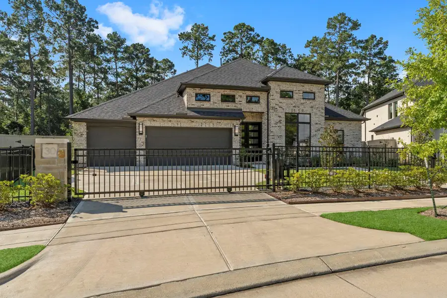 sophisticated and inviting, a perfect retreat. The sleek design, combined with the natural surroundings, makes it feel like a private sanctuary. Stunning, modern one-story home with a light-colored brick exterior and a dark roof. A black metal fence and gate secure the front of the property, providing a private and grand entrance. The large driveway is a key feature, leading to a three-car garage. The house has a contemporary aesthetic. sophisticated and inviting, a perfect retreat. The sleek design, combined with the natural surroundings, makes it feel like a private sanctuary. Stunning, modern one-story home with a light-colored brick exterior and a dark roof. A black metal fence and gate secure the front of the property, providing a private and grand entrance. The large driveway is a key feature, leading to a three-car garage. The house has a contemporary aesthetic.