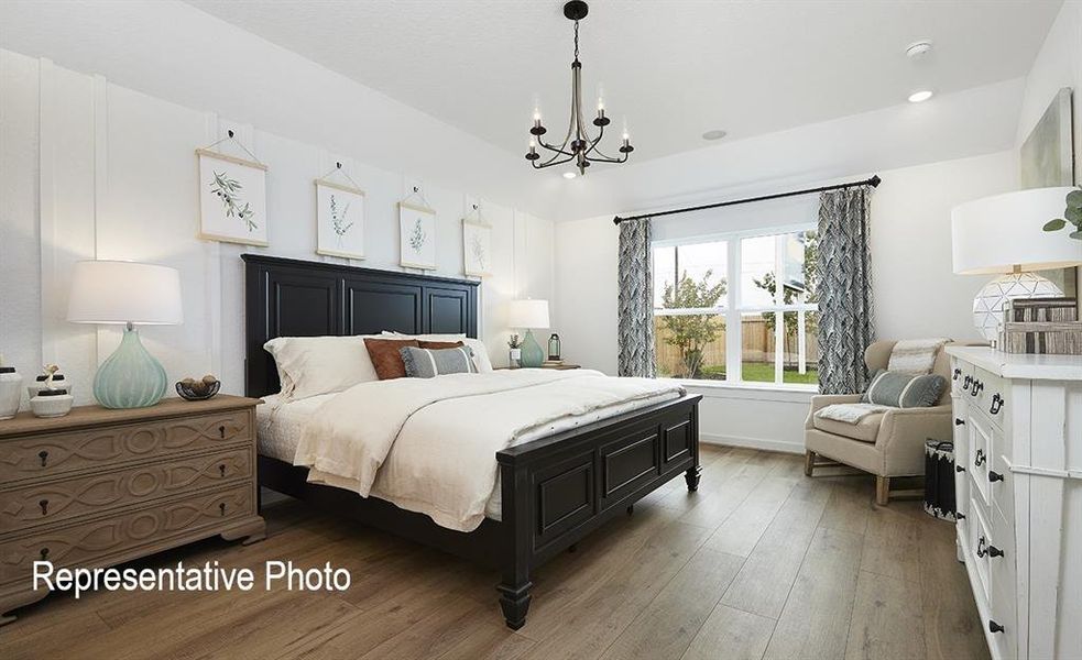 Bedroom with hardwood / wood-style flooring and a notable chandelier