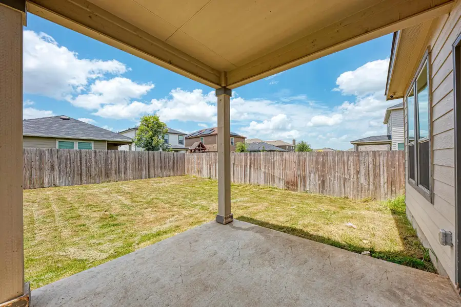 A spacious backyard with a covered concrete patio awaits outdoor enjoyment.