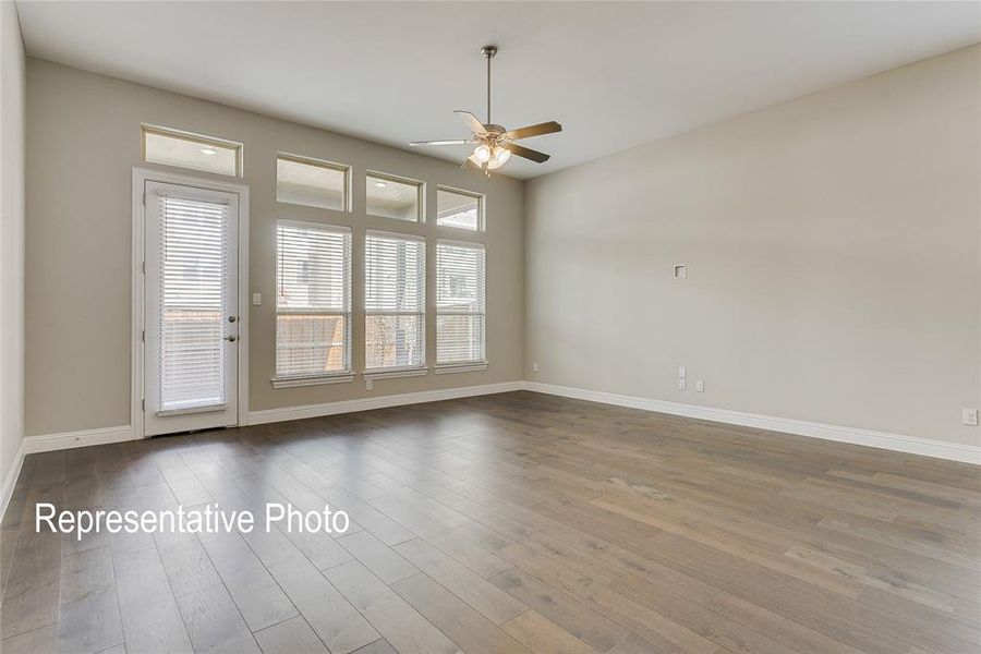 Spacious interior featuring wood-finish flooring, a contemporary ceiling fan, and high ceilings