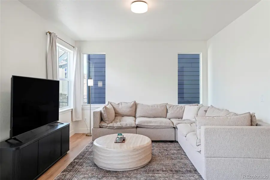 Open living area with seamless connection to the kitchen and staircase, highlighting the functional flow of this thoughtfully designed home in Three Hills