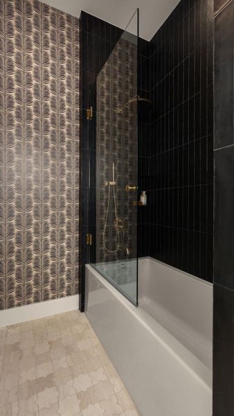 Elegant bathing space featuring a sleek bathtub and a contrasting dark tiled shower. Elegant bathing space featuring a sleek bathtub and a contrasting dark tiled shower.