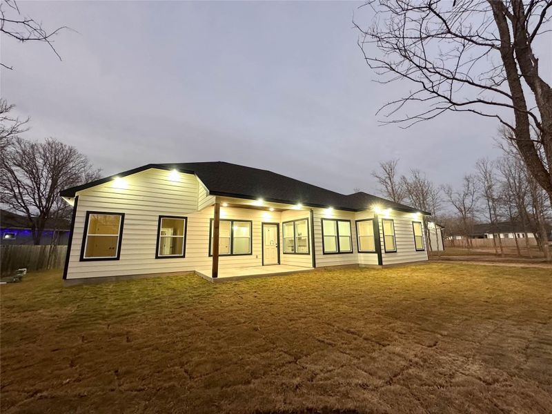 Rear view of house featuring a patio area and a lawn