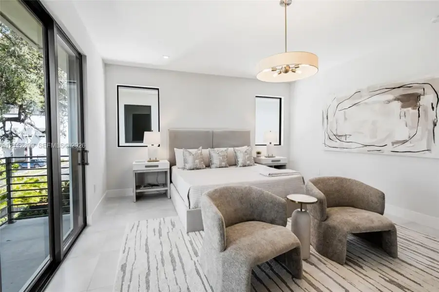 Neutral-toned room featuring large-format tile flooring, sliding glass door access to a balcony, recessed lighting, and a drum-style pendant fixture