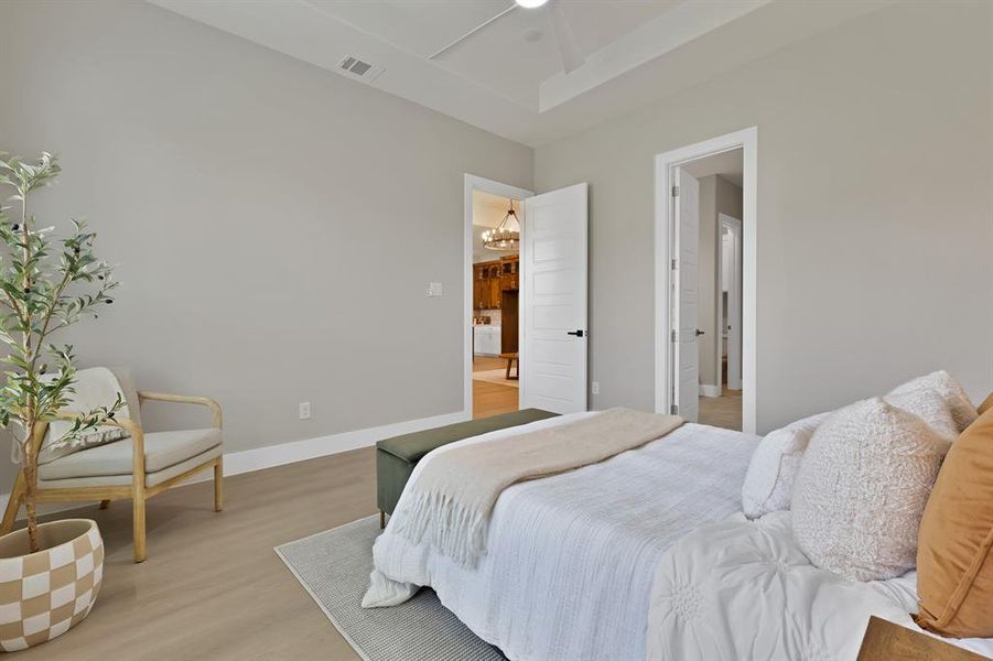Bedroom featuring light wood-style floors, baseboards, and a chandelier