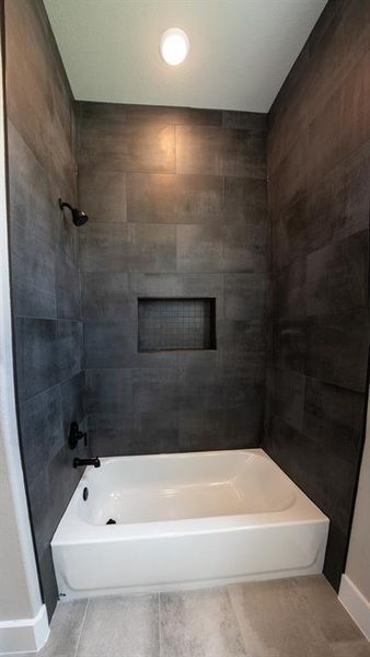 Full bath with bathing tub / shower combination and tile patterned flooring Full bath with bathing tub / shower combination and tile patterned flooring