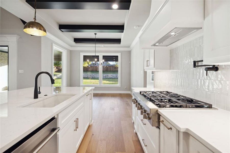 Kitchen featuring sink, tasteful backsplash, light hardwood / wood-style flooring, white cabinets, and appliances with stainless steel finishes