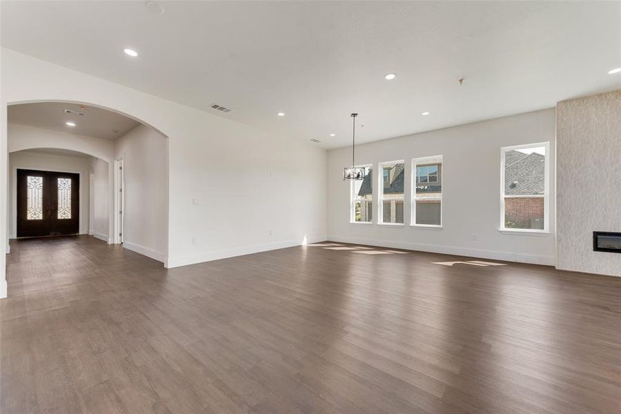 Open concept living area featuring wood-finish flooring, recessed lighting, and multiple windows Open concept living area featuring wood-finish flooring, recessed lighting, and multiple windows