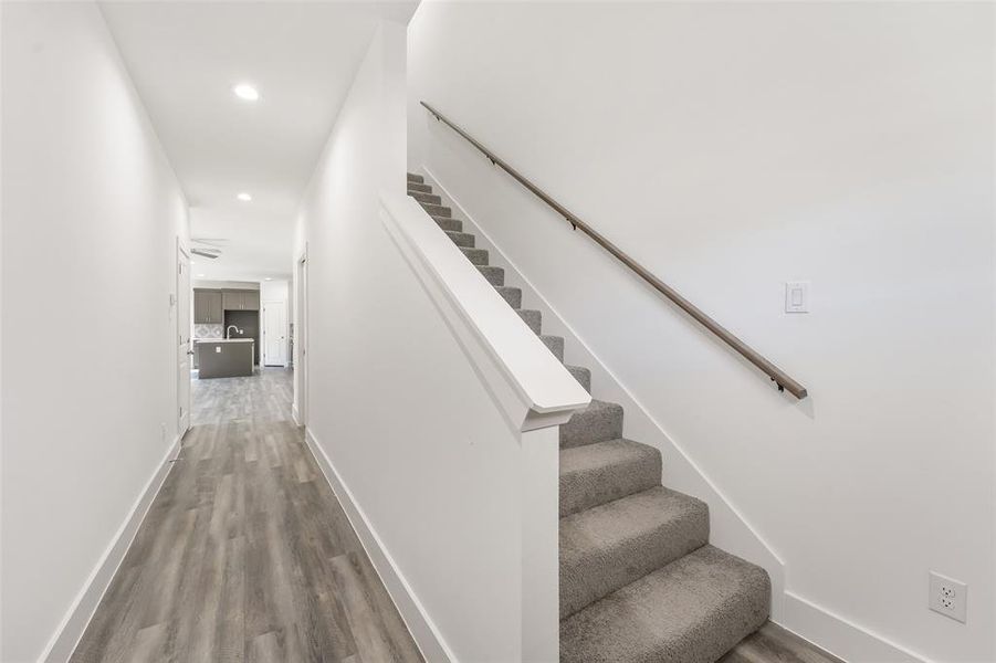 Stairs with recessed lighting and wood finished floors