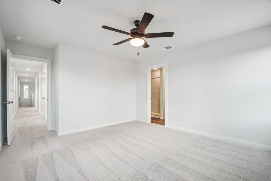 A room with a ceiling fan and a door.