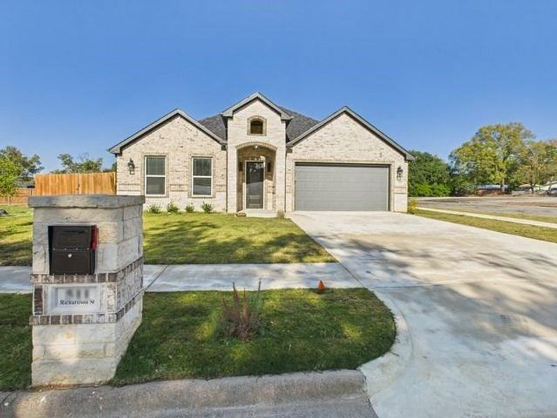 View of front of property featuring driveway, brick siding, and an attached garage View of front of property featuring driveway, brick siding, and an attached garage
