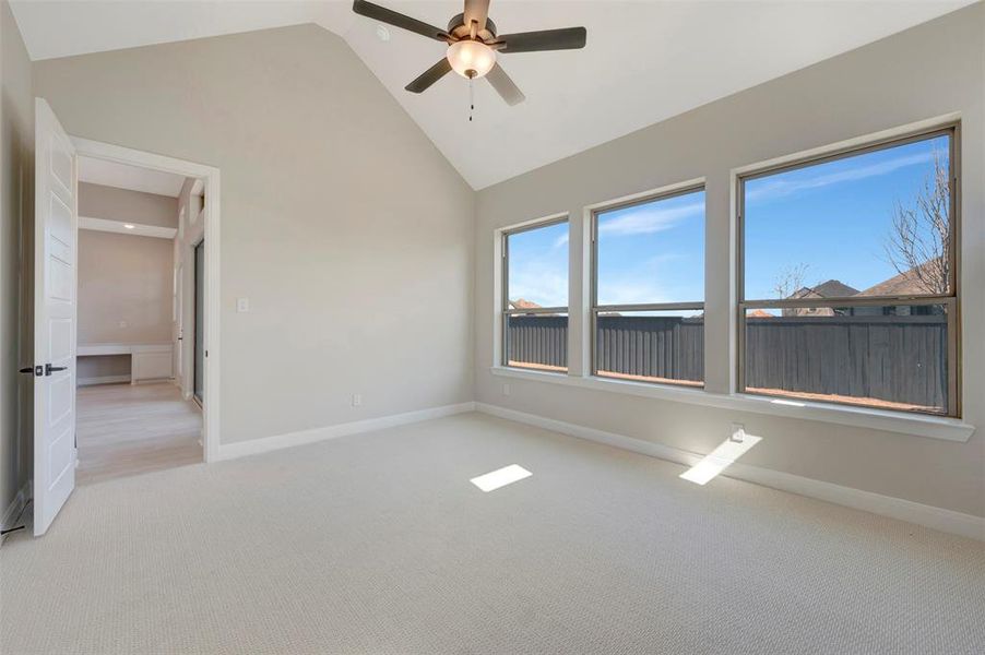 Spare room featuring light colored carpet, ceiling fan, and lofted ceiling Spare room featuring light colored carpet, ceiling fan, and lofted ceiling