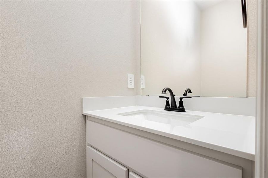 Bathroom featuring vanity and a textured wall