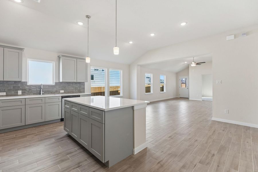 Gleaming granite counters and modern flooring define this airy kitchen and living area.