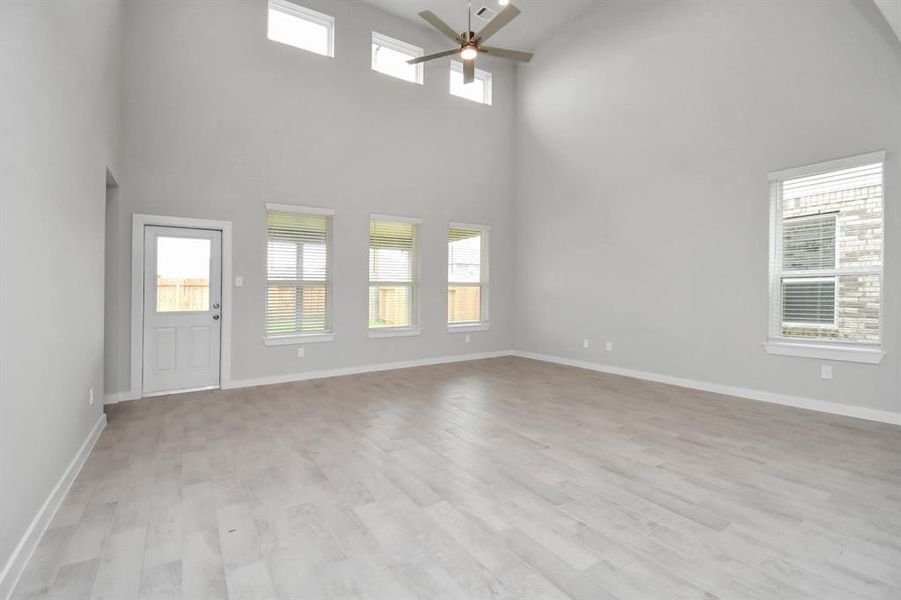 Welcome family and guests to your charming living room! With its high ceilings, recessed lighting, ceiling fan, custom paint, beautiful flooring, and large windows that let in abundant natural light, this room is perfect for gatherings.