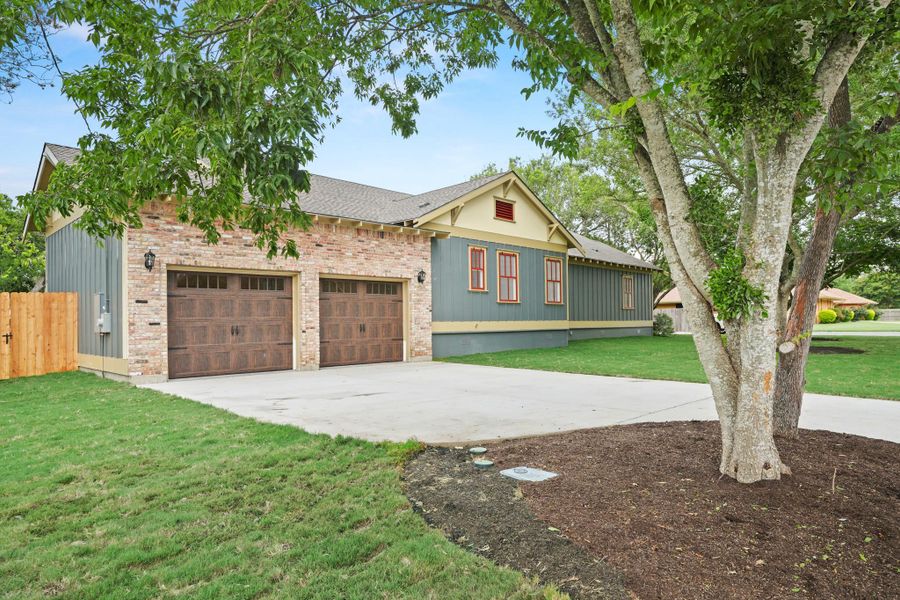 A well-maintained property showcasing a two-car garage with rich wood-toned doors and complementary brick and siding. A well-maintained property showcasing a two-car garage with rich wood-toned doors and complementary brick and siding.