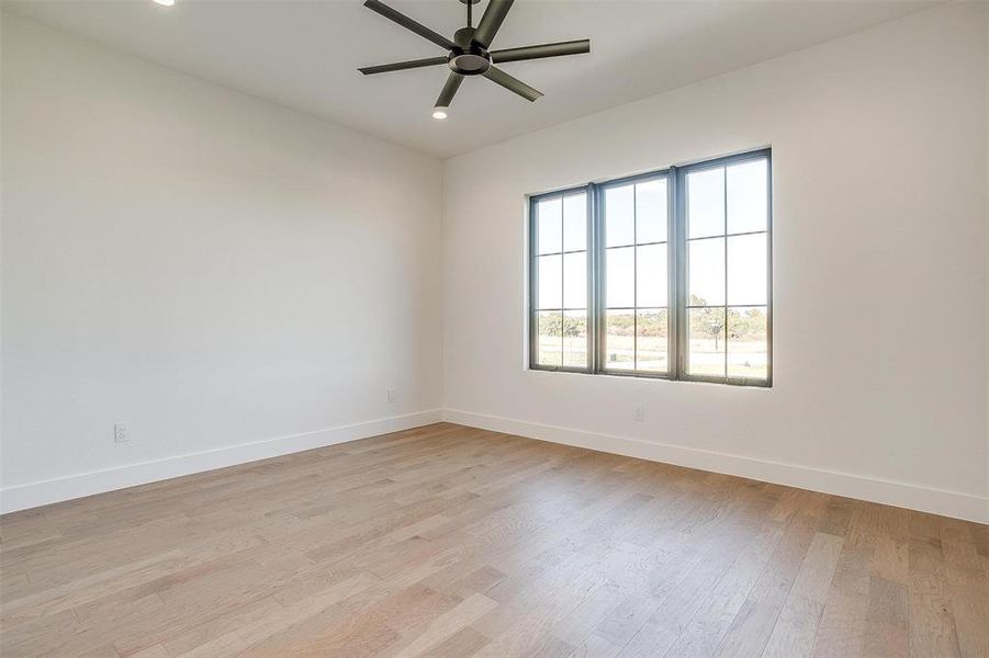 Unfurnished room with ceiling fan and light wood-type flooring