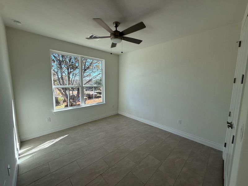 Unfurnished room featuring a ceiling fan and baseboards