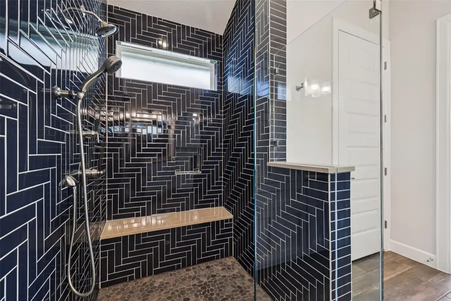 Full bath featuring tiled shower and wood finished floors