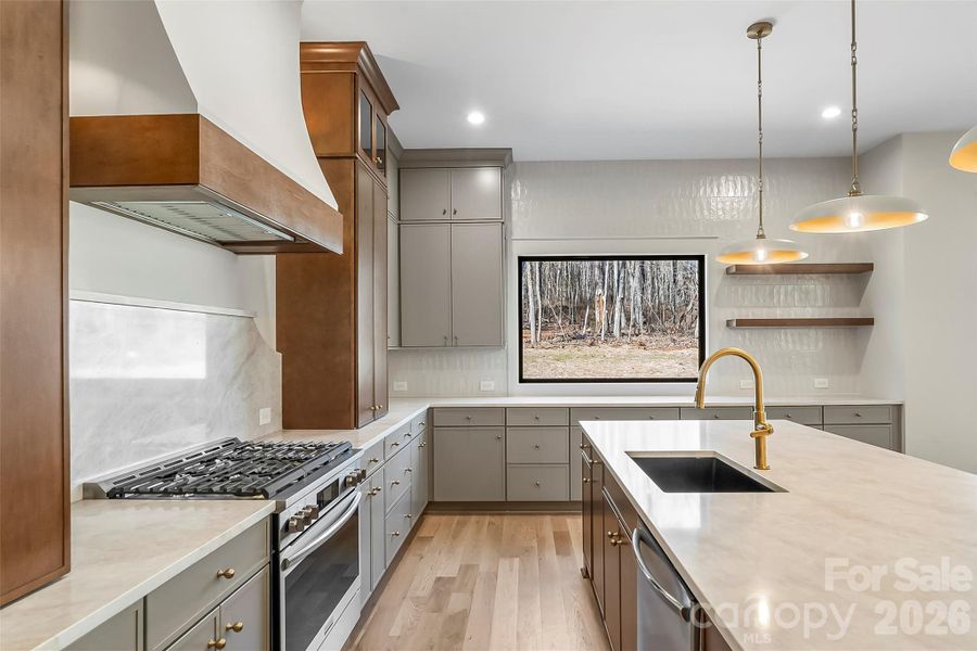 This is what kitchen dreams are made of! 6 burner gas, gorgeous quartz, custom hood, designer lighting.