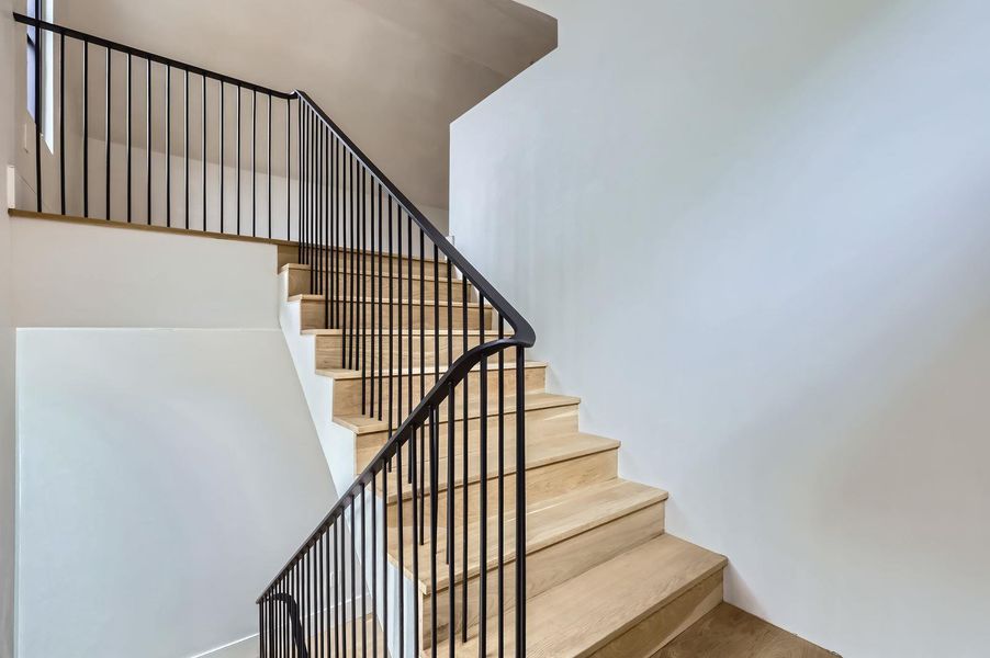 Clean lines define this striking modern staircase with rich wood treads and elegant black railings.