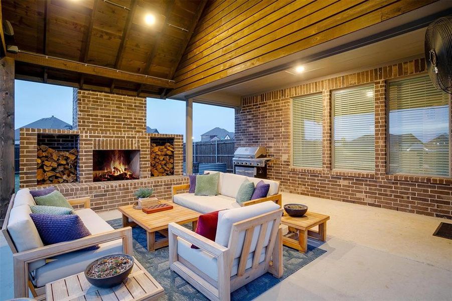 View of patio with an outdoor living space with a fireplace and grilling area