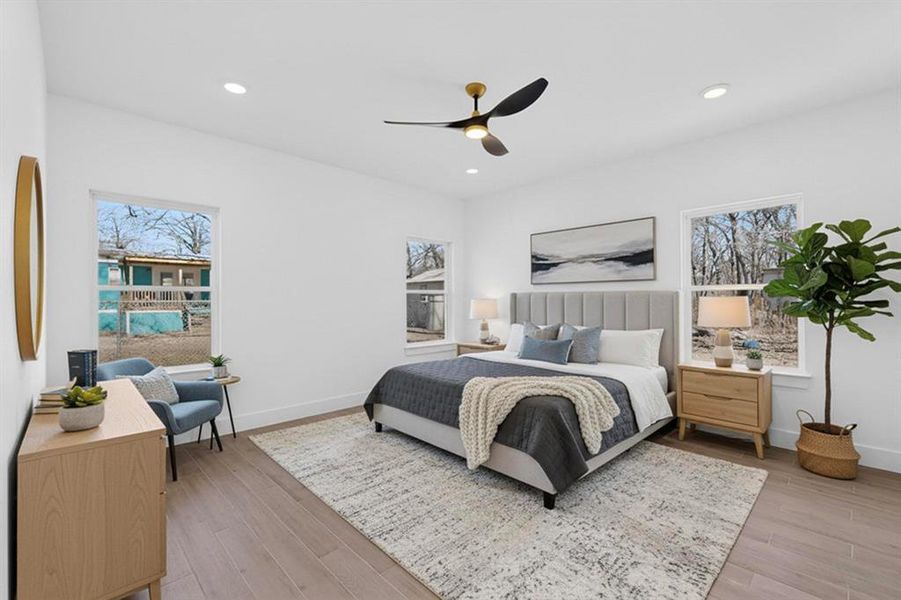 Bedroom with ceiling fan, multiple windows, light wood-style flooring, and recessed lighting