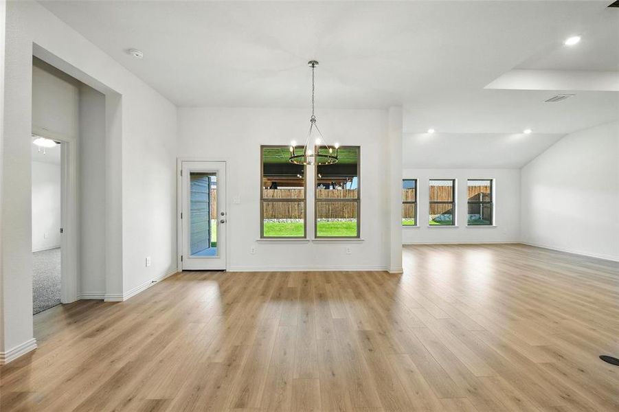 Unfurnished living room featuring a chandelier, light wood-style floors, and recessed lighting