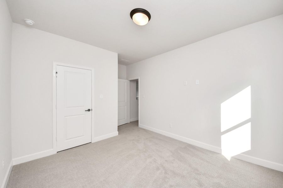 Bright bedroom with closet access and ample floor space.